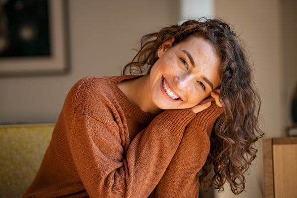 Donna felice e sorridente a simbolo dell'effetto delle emozioni sulla coerenza cardiaca