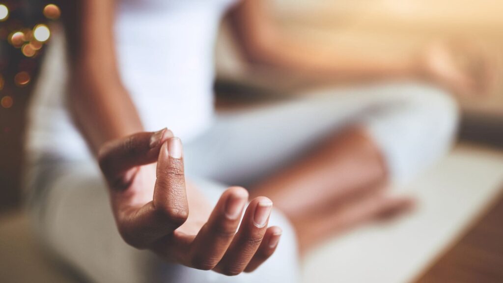 Mani e gambe in posizione meditativa a simbolo del corso Vinci la Paura dei Cambiamenti